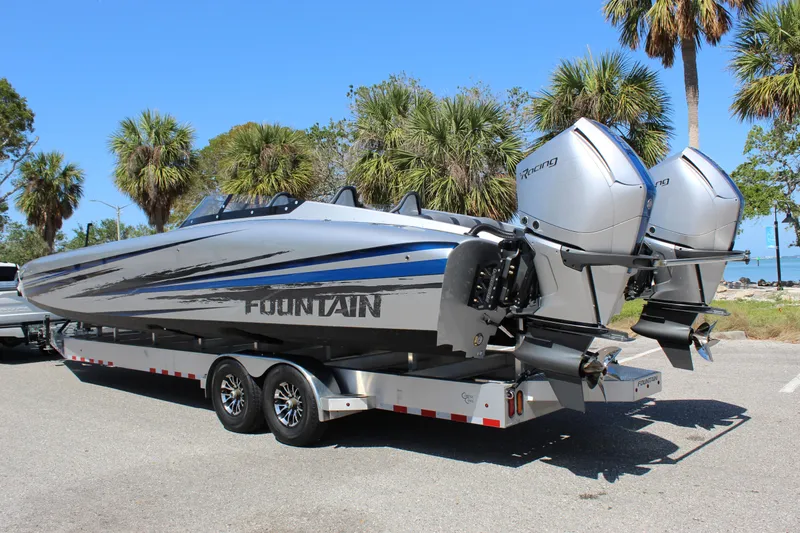 Slide: The Image of 2025 Fountain 34 Thundercat boat on trailer, dual engines, parked near palm trees. - 7