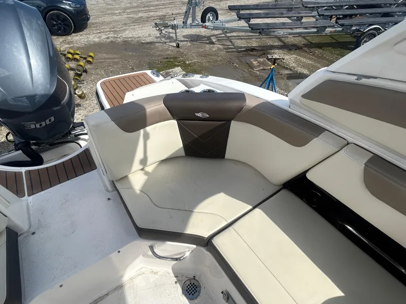 Slide: The Image of 2019 Chaparral 250 Suncoast boat interior with cushioned seating and outboard motor. - 15