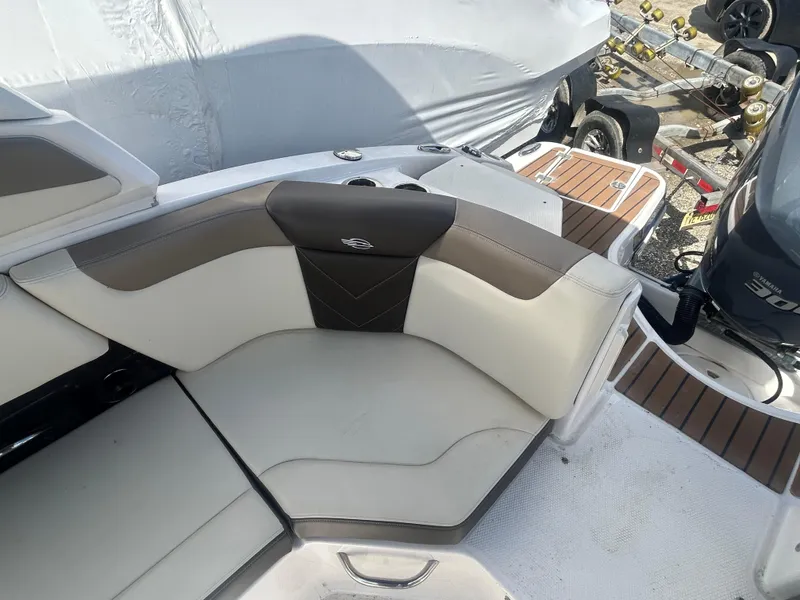 Slide: The Image of 2019 Chaparral 250 Suncoast boat interior with cushioned seating and wood accents. - 16