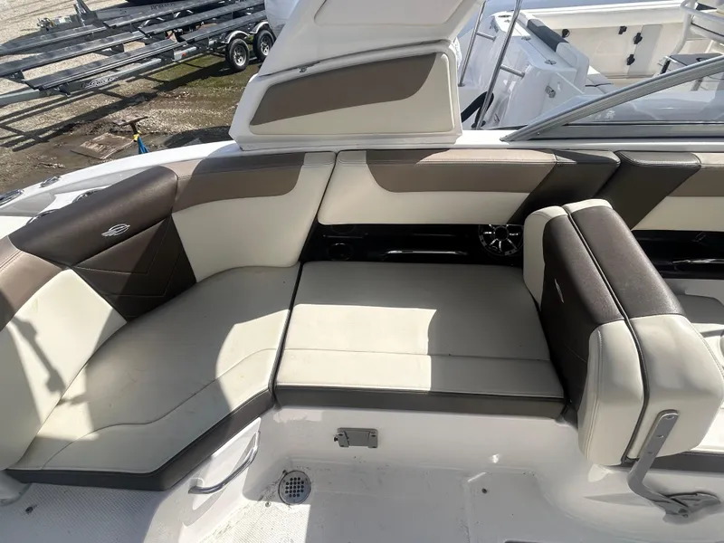 Slide: The Image of 2019 Chaparral 250 Suncoast boat interior with beige and brown seating. - 17