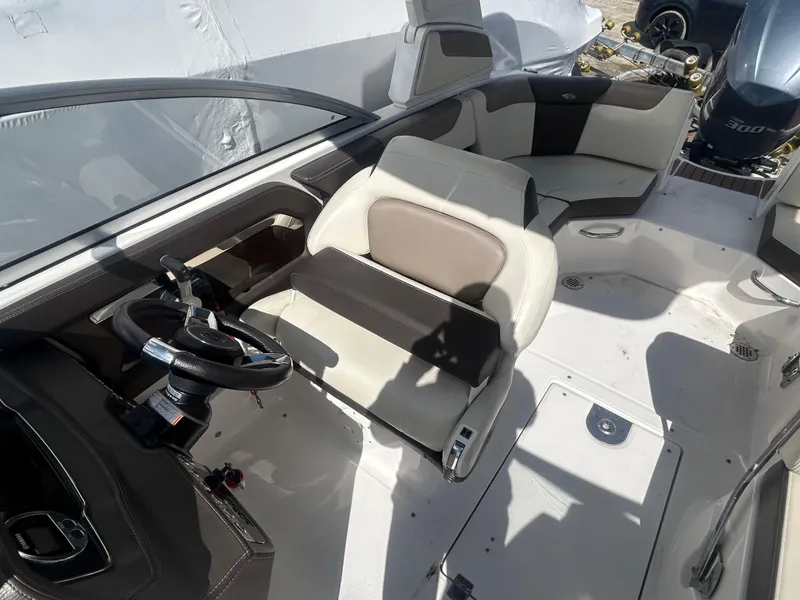 Slide: The Image of 2019 Chaparral 250 Suncoast boat interior with steering wheel and seating area. - 22