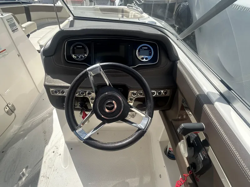 Slide: The Image of 2019 Chaparral 250 Suncoast boat dashboard with steering wheel and controls. - 24