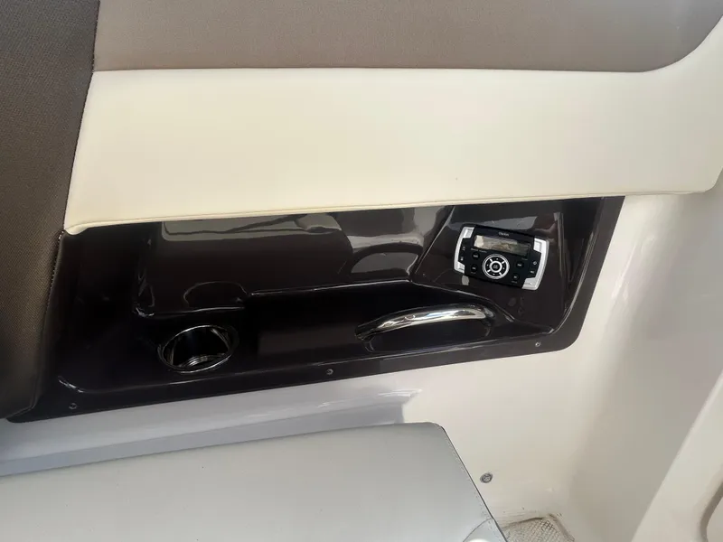 Slide: The Image of Interior detail of 2019 Chaparral 250 Suncoast boat, featuring control panel and cup holder. - 25