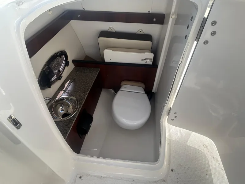 Slide: The Image of 2019 Chaparral 250 Suncoast boat interior with compact bathroom amenities. - 29