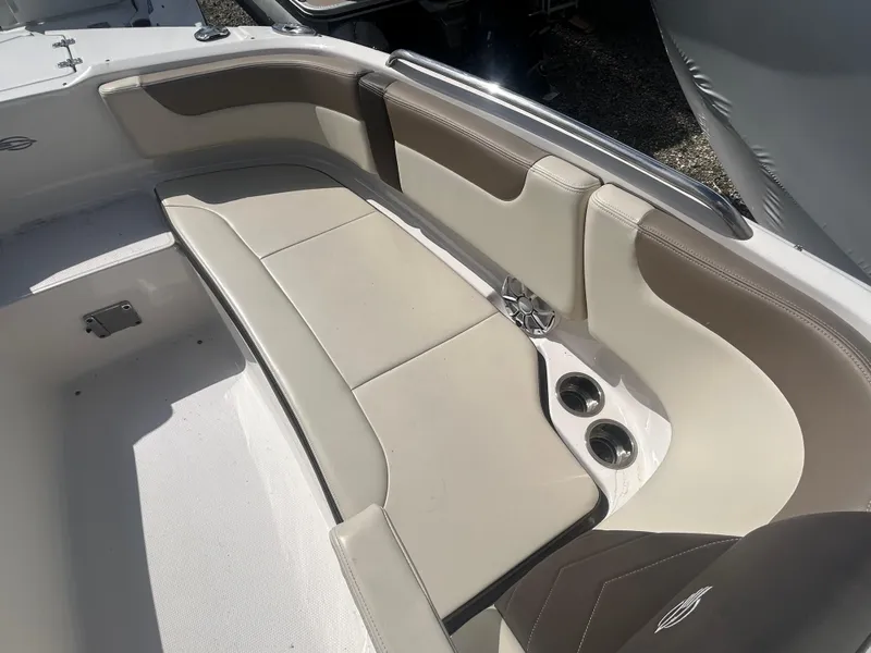 Slide: The Image of 2019 Chaparral 250 Suncoast boat interior with beige seating and cup holders. - 34