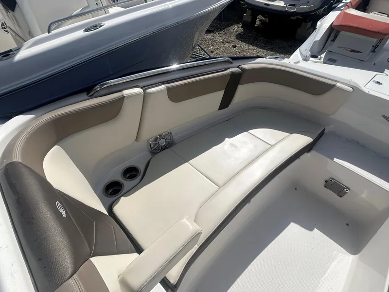 Slide: The Image of 2019 Chaparral 250 Suncoast boat interior with beige seating and cup holders. - 35