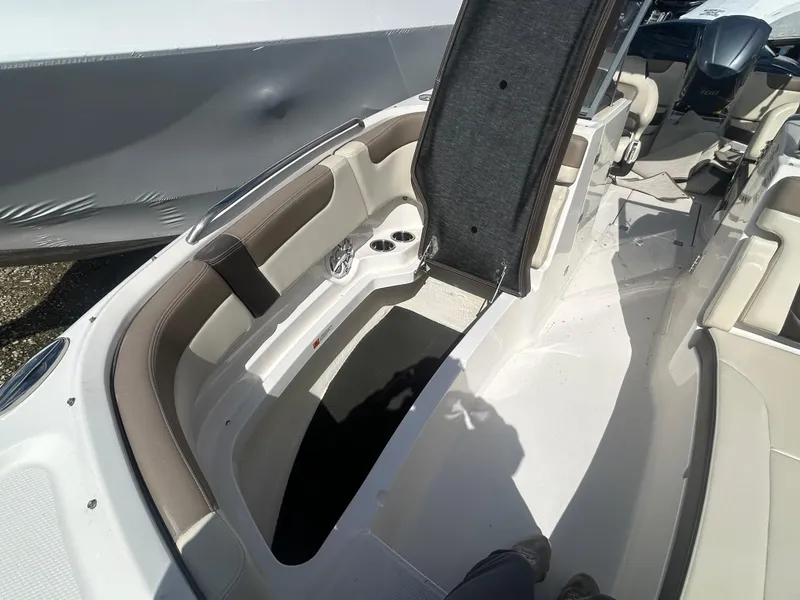 Slide: The Image of 2019 Chaparral 250 Suncoast boat interior with open storage compartment and seating area. - 36