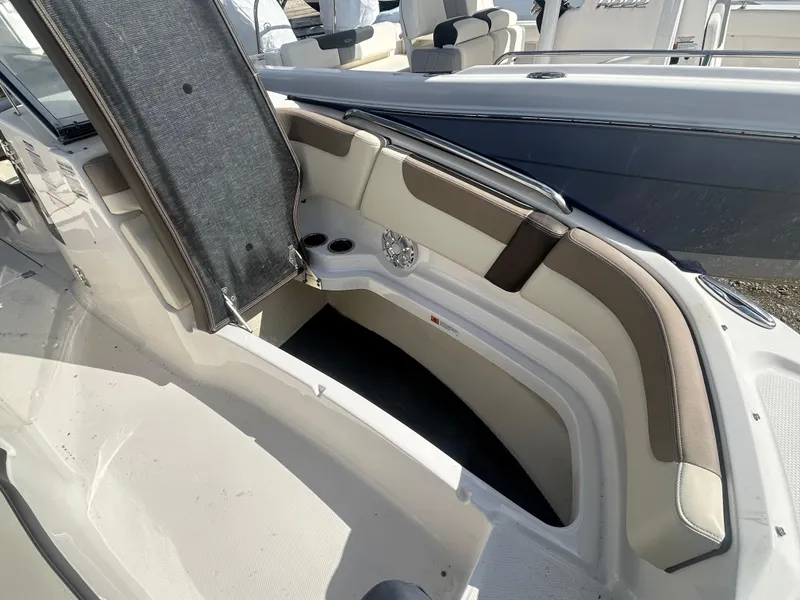 Slide: The Image of 2019 Chaparral 250 Suncoast boat interior with cushioned seating and storage compartment. - 38