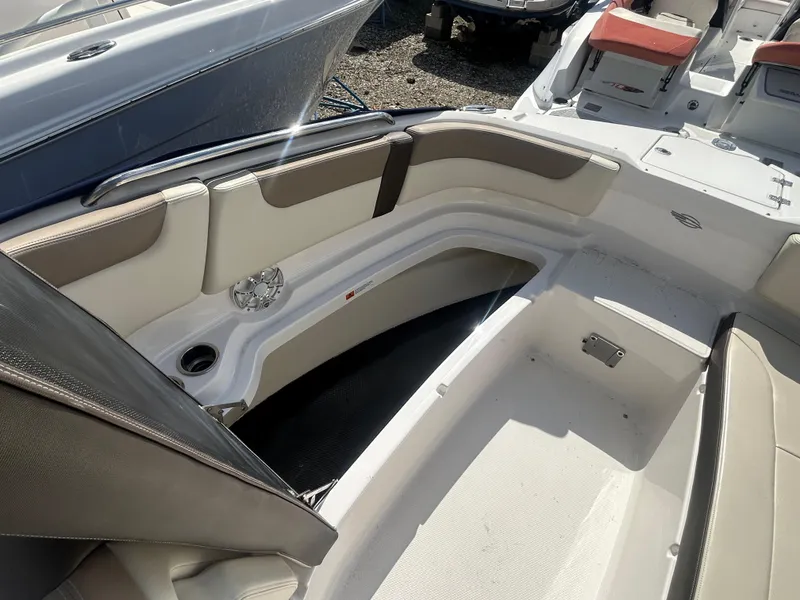 Slide: The Image of 2019 Chaparral 250 Suncoast boat interior with cushioned seating and storage compartments. - 39