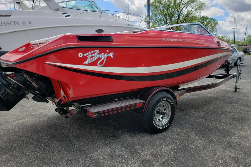 Slide: The Image of Red 1993 Baja 204 Islander boat on trailer, parked outdoors. - 2