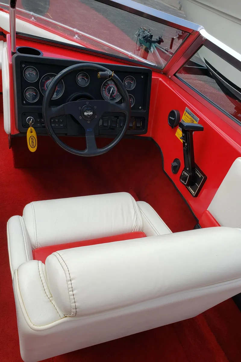 Slide: The Image of 1993 Baja 204 Islander boat interior with red dashboard and white seating. - 3