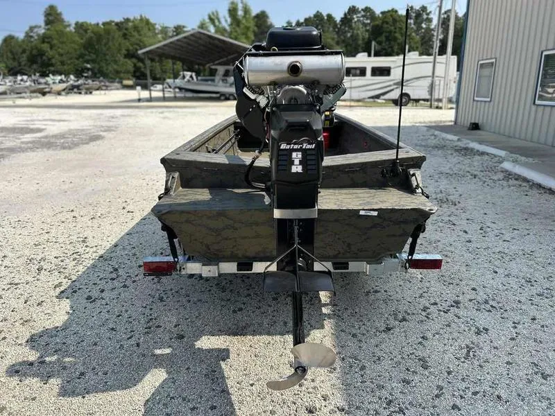 Slide: The Image of 2025 Gator Tail 1754 Extreme Series boat with motor, parked on gravel. - 6