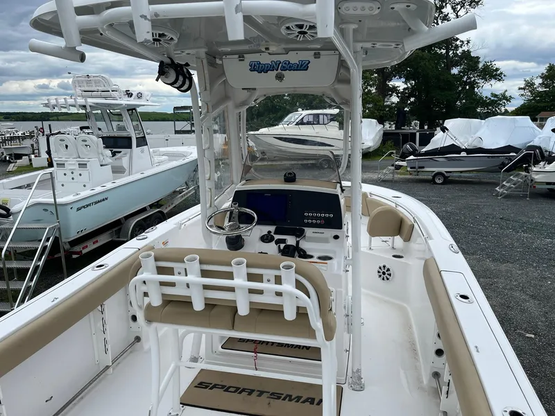 Slide: The Image of 2017 Sportsman Open 232 Center Console boat with beige seating and modern dashboard. - 7