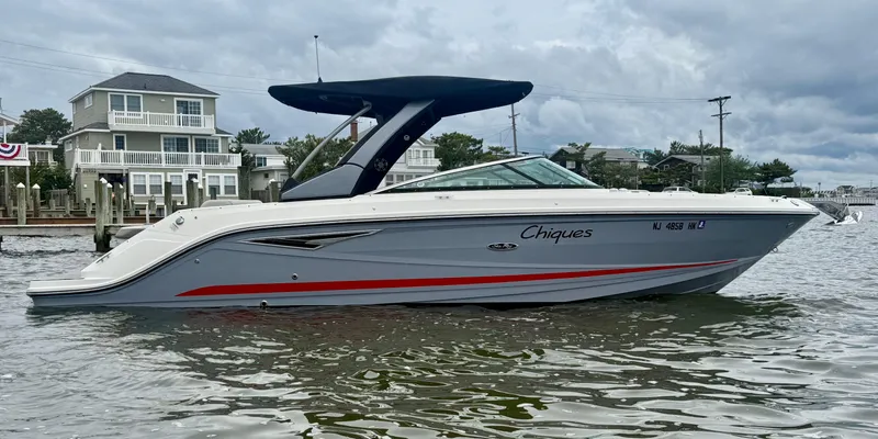 Slide: The Image of 2022 Sea Ray SLX 280 boat on water near waterfront homes. - 1