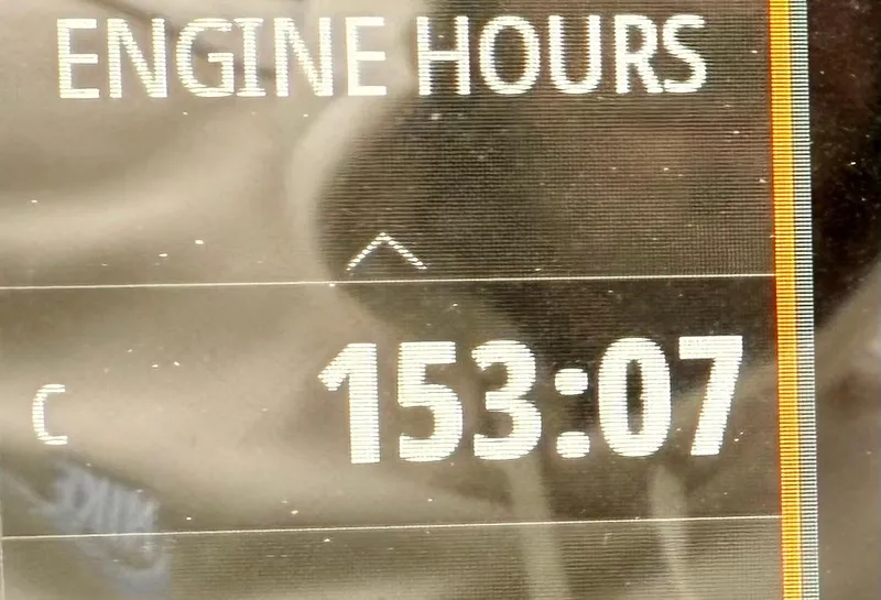 Slide: The Image of Sea Ray SLX 280 engine hours display showing 153:07. - 6