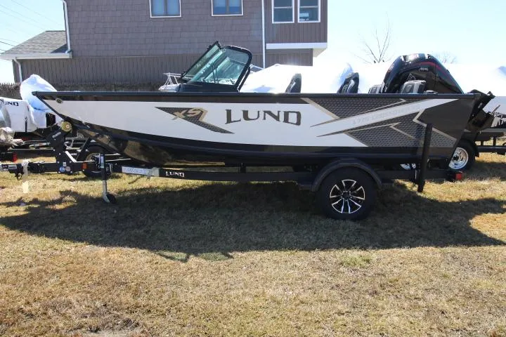 Slide: The Image of 2025 Lund 1775 Crossover XS boat on trailer, parked on grass. - 0