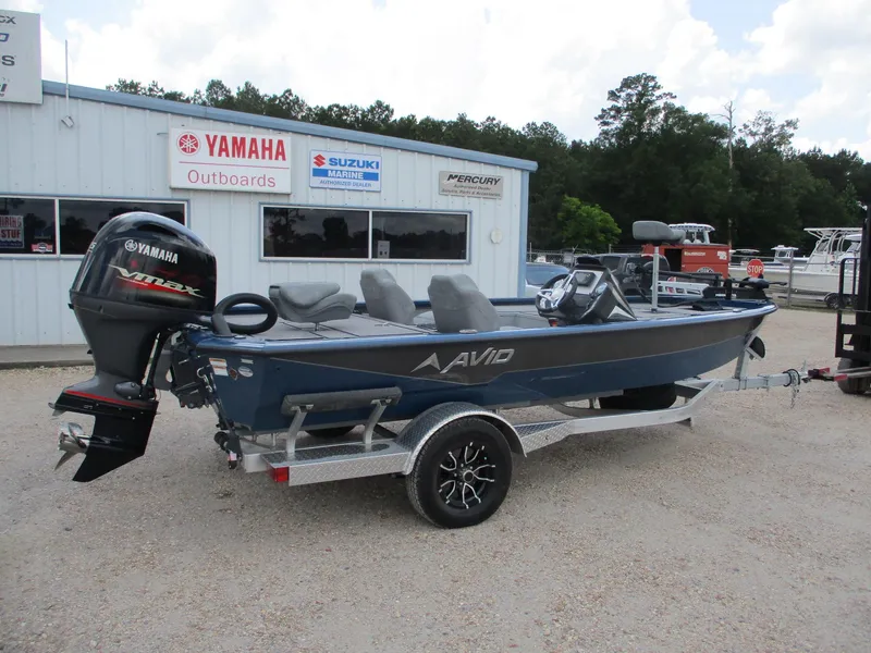 Slide: The Image of 2024 Avid 18XB boat with Yamaha outboard motor on a trailer, parked outside dealership. - 0