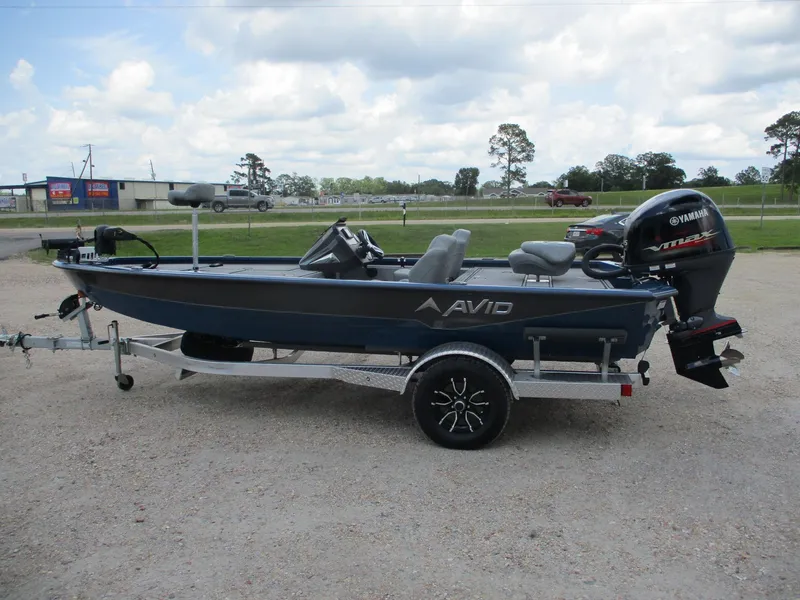 Slide: The Image of 2024 Avid 18XB boat on trailer with Yamaha outboard motor, parked outdoors. - 2