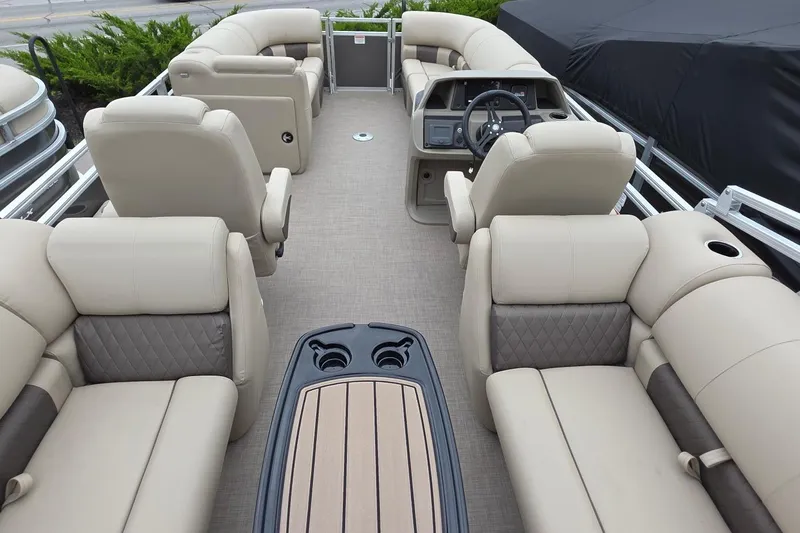 The Image of 2025 Sun Tracker PB 22 DLX pontoon boat interior with luxurious seating and steering console. - 0