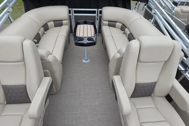 Slide: The Image of 2025 Sun Tracker PB 22 DLX pontoon boat interior with beige seating and central table. - 15
