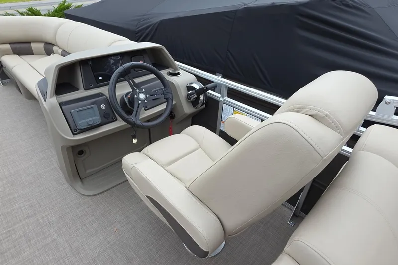 Slide: The Image of 2025 Sun Tracker PB 22 DLX boat interior with steering console and beige seating. - 3