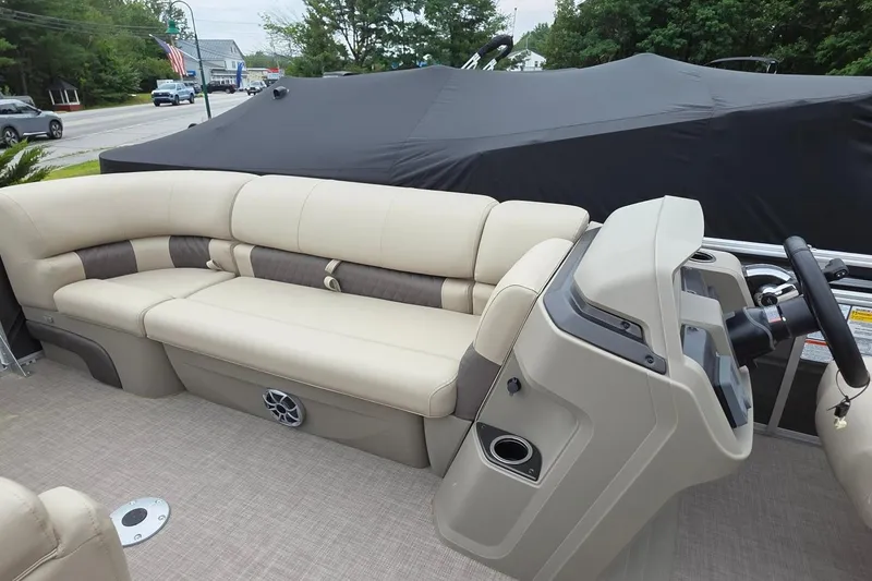 Slide: The Image of 2025 Sun Tracker PB 22 DLX pontoon boat interior with beige seating and steering console. - 8
