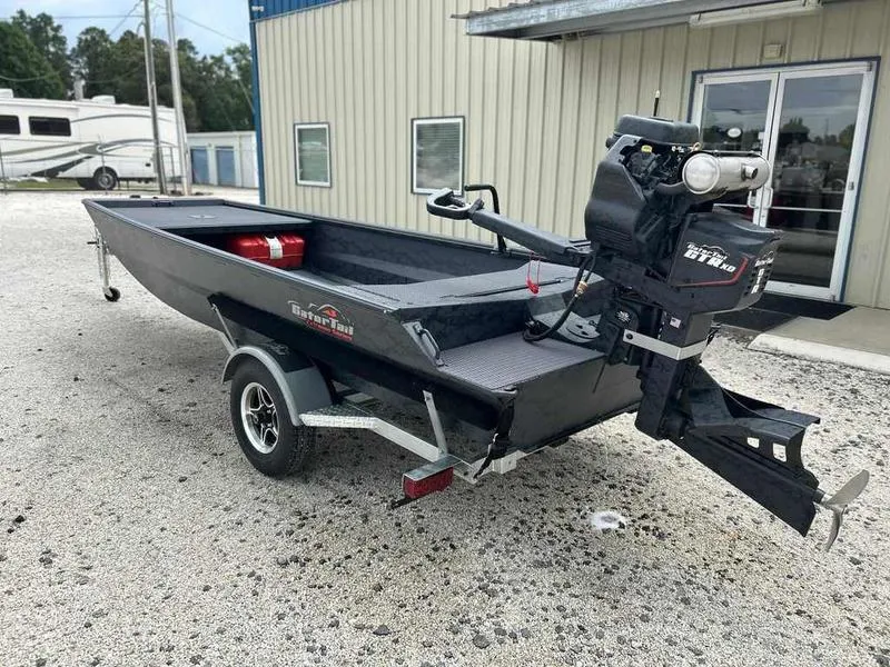 Slide: The Image of 2025 Gator Tail 1754 Extreme Series boat with motor on trailer, parked outside a building. - 12
