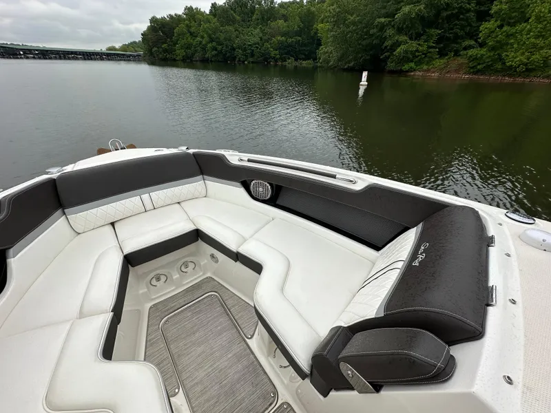 Slide: The Image of 2017 Sea Ray SLX 280 boat interior with plush seating on a calm lake. - 11