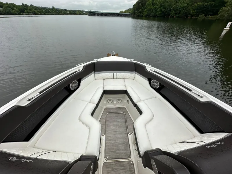 Slide: The Image of 2017 Sea Ray SLX 280 boat interior with white seating on a calm lake. - 12