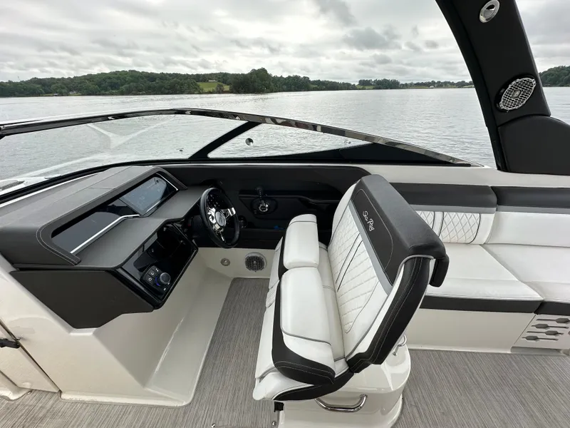 Slide: The Image of 2017 Sea Ray SLX 280 boat interior with sleek dashboard and comfortable seating on a calm lake. - 20