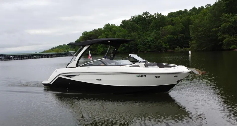 Slide: The Image of 2017 Sea Ray SLX 280 boat cruising on a calm lake with lush green trees. - 6
