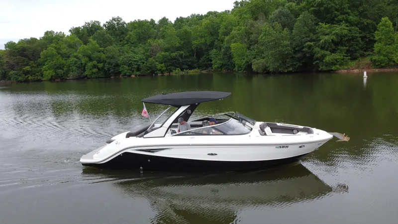 Slide: The Image of 2017 Sea Ray SLX 280 boat cruising on a calm lake with lush green trees. - 7