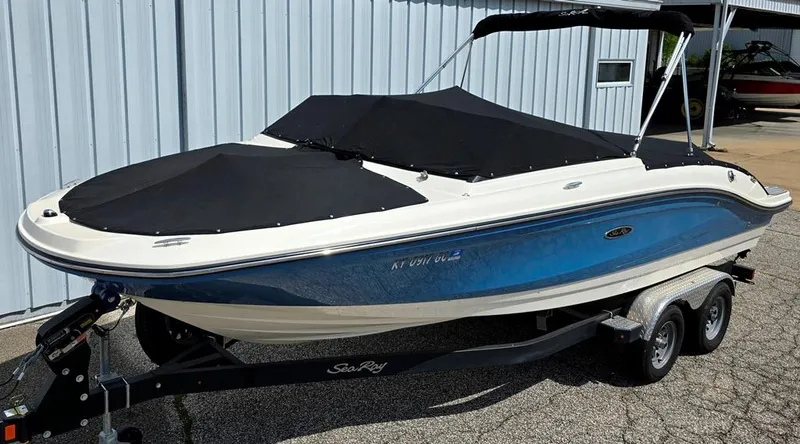 Slide: The Image of 2020 Sea Ray SPX 210 boat on trailer, covered, blue and white exterior. - 14