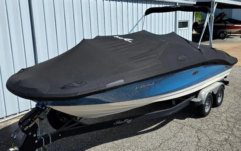 Slide: The Image of 2020 Sea Ray SPX 210 boat with cover on trailer, parked outdoors. - 15