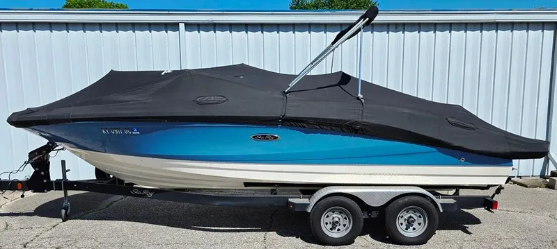 Slide: The Image of 2020 Sea Ray SPX 210 boat on trailer, covered, blue and white hull. - 19