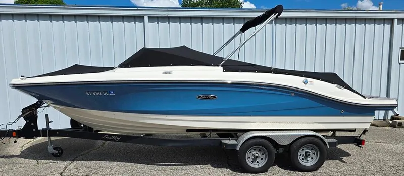 Slide: The Image of 2020 Sea Ray SPX 210 boat on trailer, blue hull, parked outdoors. - 20