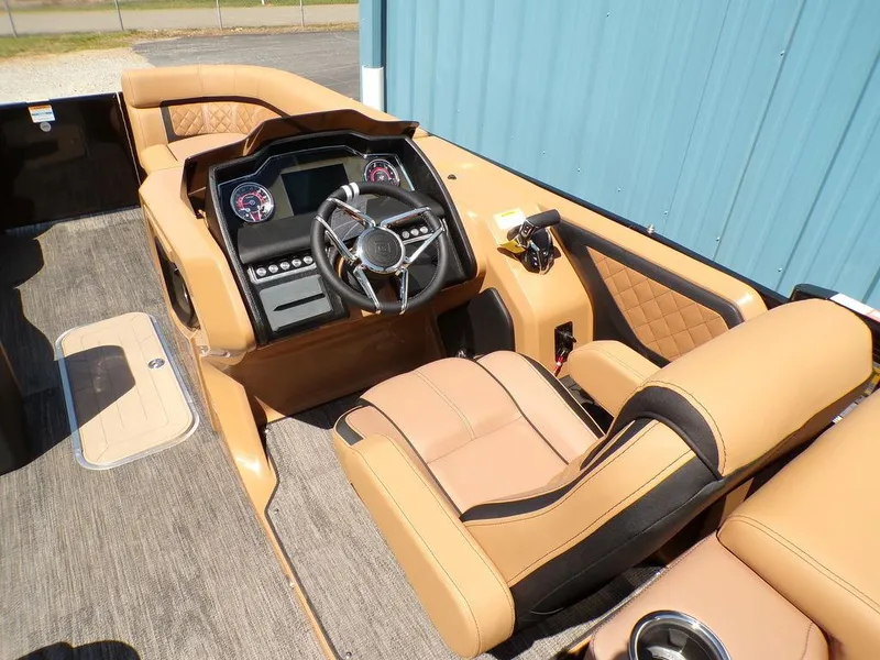 Slide: The Image of Interior of 2025 Godfrey AquaPatio 235 SBC boat with tan seating and modern dashboard. - 7
