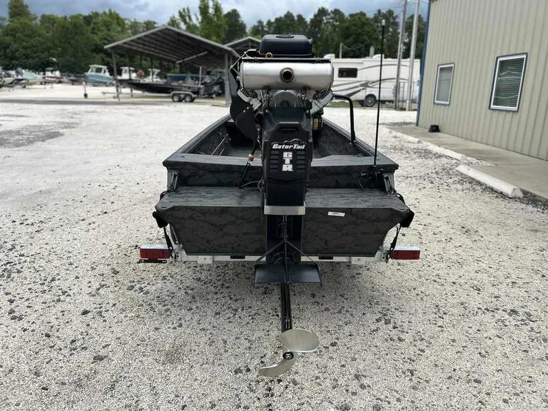 Slide: The Image of 2025 Gator Tail 1748 Gator Series boat with motor, parked on gravel. - 7