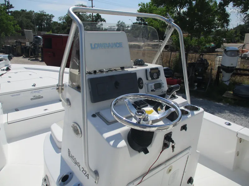 Slide: The Image of 2010 BlackJack 224 boat console with steering wheel and navigation equipment. - 14
