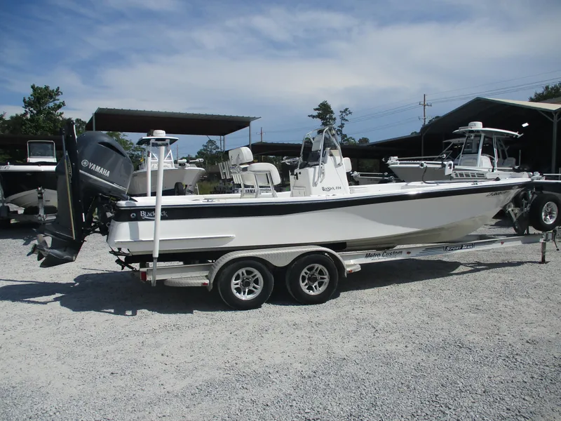 Slide: The Image of 2010 BlackJack 224 boat on trailer with Yamaha outboard motor, parked on gravel. - 5