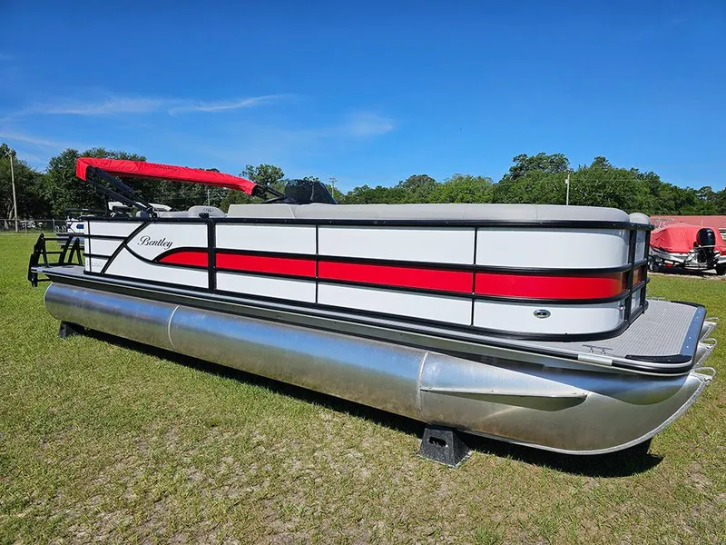 Slide: The Image of 2025 Bentley Pontoons Legacy 243 Cruise Tritoon in showroom, featuring sleek design and vibrant accents. - 2