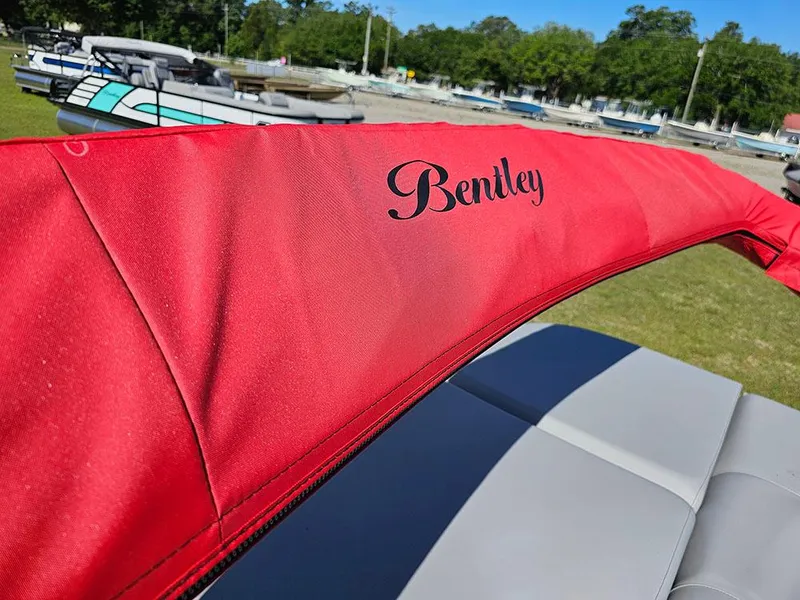 Slide: The Image of 2025 Bentley Pontoons Legacy 243 Cruise Tritoon interior with plush seating and modern dashboard. - 22