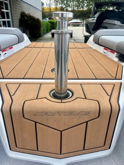 Slide: The Image of 2023 Nautique Super Air Nautique GS22 boat deck with sleek design and polished metal features. - 12