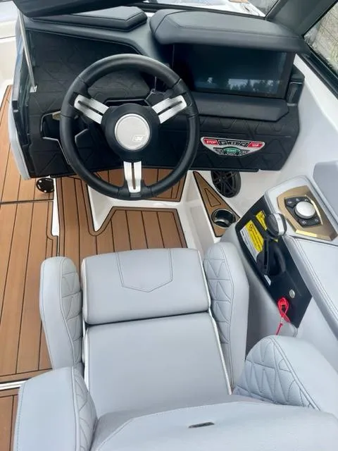 Slide: The Image of 2023 Nautique Super Air Nautique GS22 boat interior with steering wheel and dashboard. - 15
