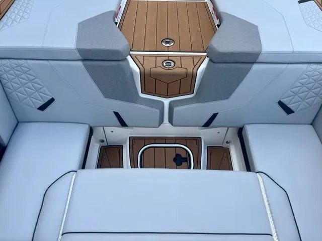 Slide: The Image of 2023 Nautique Super Air Nautique GS22 boat interior with cushioned seating and teak flooring. - 9