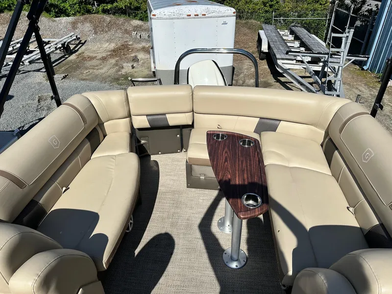 Slide: The Image of 2017 Godfrey Aqua Patio 235UL pontoon boat with beige seating and wooden table. - 3