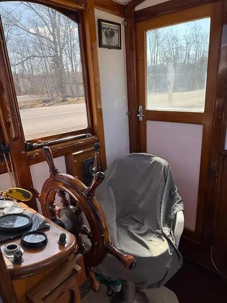 Slide: The Image of Interior of 1999 Glen-L BO-JEST boat with wooden steering wheel and covered chair. - 10