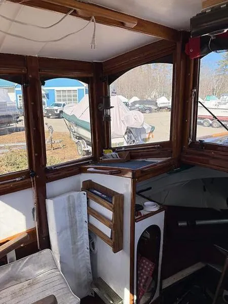 Slide: The Image of Interior of a 1999 Glen-L BO-JEST boat with wooden accents and outdoor view. - 11