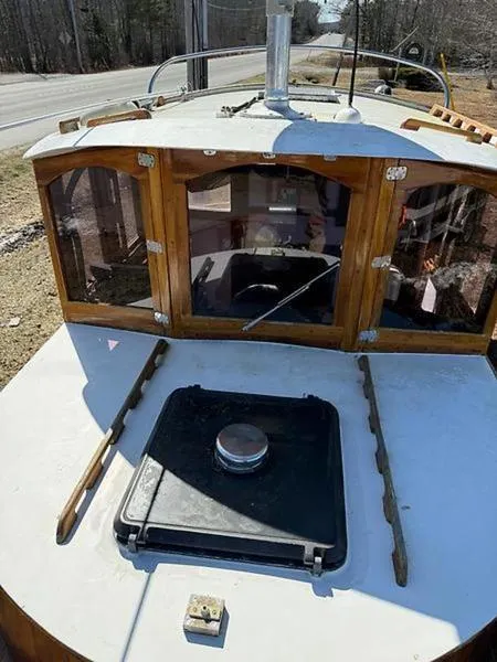 Slide: The Image of 1999 Glen-L BO-JEST boat with wooden cabin and deck hatch, parked near a road. - 20