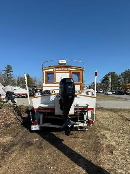 Slide: The Image of 1999 Glen-L BO-JEST boat with outboard motor, parked on grass under clear blue sky. - 8